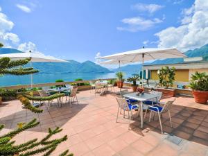 Un patio con mesas, sillas y sombrillas. en Apartment Lakeview App- 603 by Interhome, en Moscia 21 fotos más