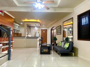 a living room with a couch and a ceiling fan at Spacious Modern 4BR Home with 24hr Security and Parking in Cagayan de Oro
