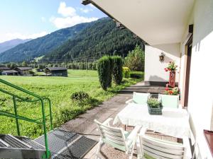 a patio with a table and chairs and mountains in the background at Apartment Studio Grenta by Interhome in Gortipohl