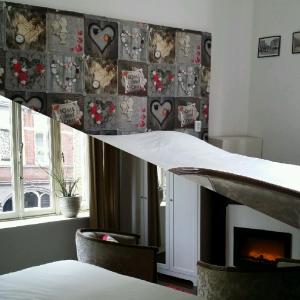 a bedroom with a fireplace and a wall with hearts at De Roermondse beleving in Roermond
