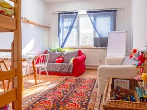 a living room with a red couch and a rug at Apartment ProFamily by Interhome in Jáchymov