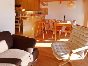 Una sala de estar y una cocina con un sofá y una mesa. en Apartment Les Arsets 01-203 by Interhome, en Taveyannaz