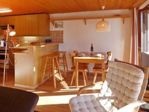Una cocina y una sala de estar con mesa y sillas. en Apartment Les Arsets 01-203 by Interhome, en Taveyannaz
