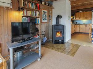 a living room with a fireplace and a stove at Holiday Home Asel - 1km from the sea by Interhome in Sønderho