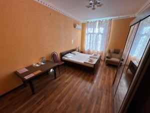 ein kleines Zimmer mit einem Bett und einem Tisch in der Unterkunft House of Timur in Buxoro