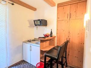 a small kitchen with a stove and a chair at Apartment Cheeky Apartment-5 by Interhome in Oberndorf in Tirol