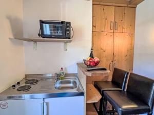 a small kitchen with a sink and a microwave at Apartment Cheeky Apartment-5 by Interhome in Oberndorf in Tirol