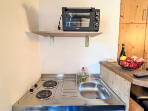 a small kitchen with a sink and a microwave at Apartment Cheeky Apartment-5 by Interhome in Oberndorf in Tirol