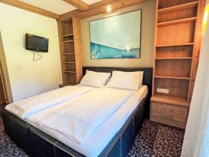 a small bedroom with a bed and a tv at Apartment Cheeky Apartment-5 by Interhome in Oberndorf in Tirol +11 photos