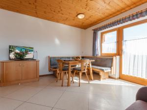 a living room with a table and a couch at Apartment Voithofer-6 by Interhome in Königsleiten