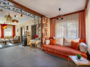 a living room with a red couch in front of a mirror at Holiday Home Elisabeth by Interhome in Mallnitz