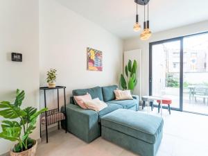 a living room with a blue couch and a table at Holiday Home Lili's with terrace by Interhome in Blankenberge