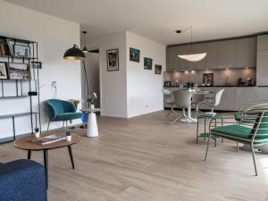 a living room with chairs and tables and a kitchen at Studio Les Oréades C by Interhome in La Tour-de-Peilz