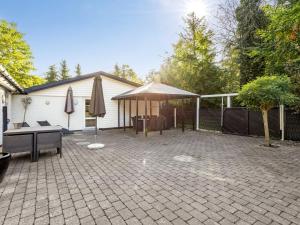 a patio with a tent and a table and umbrella at Holiday Home Ranka - 300m from the sea by Interhome in Strøby Ladeplads +21 photos
