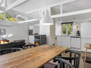 a kitchen and dining room with a wooden table and chairs at Holiday Home Ranka - 300m from the sea by Interhome in Strøby Ladeplads