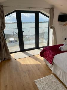 a bedroom with a large window with a view of the ocean at Ten Admiralty Pier in Shotley Gate