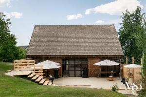 a barn with a table and umbrellas in front of it at SIM House & Barn in Săcele