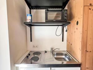 a small kitchen with a sink and a microwave at Apartment Cheeky Apartment-3 by Interhome in Oberndorf in Tirol