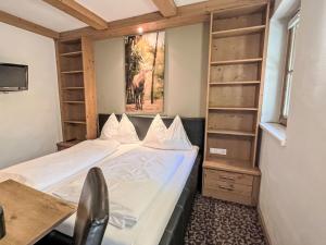 a small room with a bed and a desk and shelves at Apartment Cheeky Apartment-3 by Interhome in Oberndorf in Tirol +8 photos
