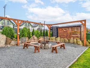 a picnic table and benches in a park at Chalet Osada Orlica by Interhome in Lasowka