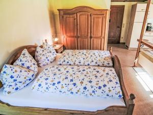 a bed with blue and white sheets and pillows at Studio Studio Biara mit Wintergarten by Interhome in Gortipohl