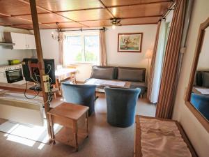 a living room with a couch and a table at Studio Studio Biara mit Wintergarten by Interhome in Gortipohl