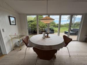a dining room with a table with chairs and a lamp at Holiday Home Gun - 300m to the fjord by Interhome in Glostrup
