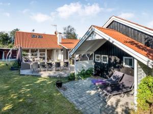 a house with an orange roof and a patio at Holiday Home Tede - 1km from the sea by Interhome in Ebeltoft
