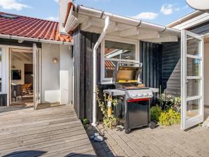 a barbecue on a patio outside of a house at Holiday Home Tede - 1km from the sea by Interhome in Ebeltoft