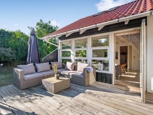a patio with couches and an umbrella on a deck at Holiday Home Tede - 1km from the sea by Interhome in Ebeltoft