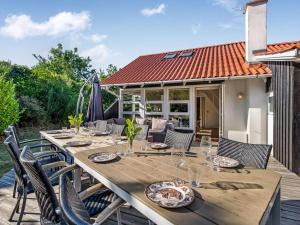 a long wooden table and chairs on a deck at Holiday Home Tede - 1km from the sea by Interhome in Ebeltoft