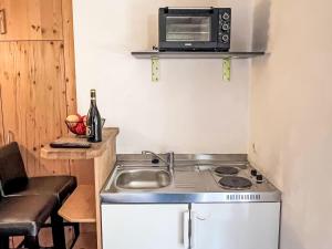 uma pequena cozinha com pia e micro-ondas em Apartment Cheeky Apartment-2 by Interhome em Oberndorf in Tirol mais 10 fotografias