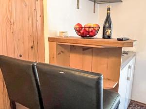 uma cadeira com uma garrafa de vinho e uma tigela de frutas em Apartment Cheeky Apartment-2 by Interhome em Oberndorf in Tirol