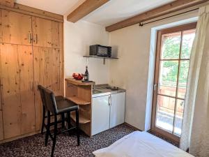 uma pequena cozinha com uma secretária e uma cadeira num quarto em Apartment Cheeky Apartment-2 by Interhome em Oberndorf in Tirol