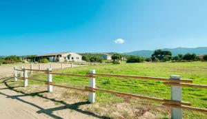 a wooden fence in front of a field at ISA - Lofts with private outdoor area and swimming-pool in Badesi in Badesi