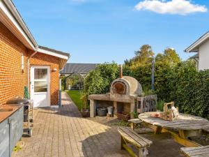 a patio with a pizza oven and a table at Holiday Home Wraghi - 21km from the sea by Interhome in Højer