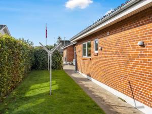 a windmill in the grass next to a brick building at Holiday Home Wraghi - 21km from the sea by Interhome in Højer +15 photos
