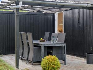 an outdoor table with chairs and a bowl of fruit on it at Holiday Home Baarde - 1-2km from the sea by Interhome in Vejby