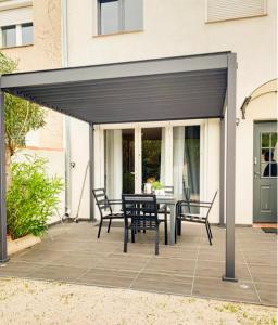awning over a patio with a table and chairs at Appartement cosy avec terrasse Canet-en-Roussillon in Canet-en-Roussillon