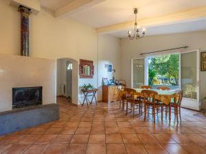 a living room with a table and chairs and a fireplace at Villa Palmeraie by Interhome in Hyères