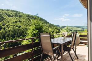 a table and chairs on a balcony with a view at Ferienwohnungen Bergnest Winterberg in Winterberg