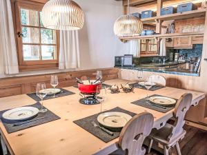 a kitchen with a wooden table with chairs and glasses at Chalet Spunda Biala by Interhome in Laax