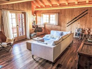 a living room with a couch and a table at Chalet Spunda Biala by Interhome in Laax