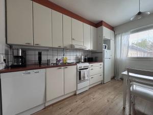 eine Küche mit weißen Schränken und weißen Geräten in der Unterkunft Kotimaailma - Cozy and spacious apartment in Seinäjoki