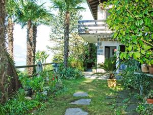 Un jardín con palmeras y una casa. en Apartment App- 1 by Interhome, en Vairano