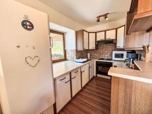 a kitchen with a refrigerator with a heart magnet on it at Apartment Hochstuhlblick by Interhome in Pugrad