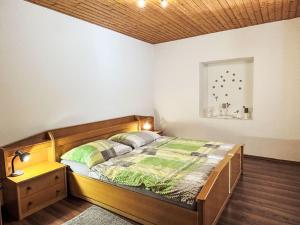 a bedroom with a wooden bed and a night stand at Apartment Hochstuhlblick by Interhome in Pugrad
