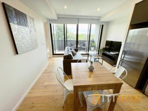 un salon avec une table et un canapé dans l'établissement Lavish in Lyneham - 2BD 1Bth Apt, à Canberra