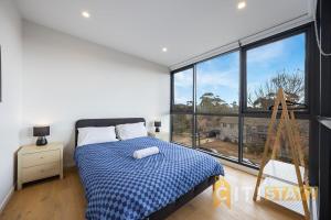 une chambre avec un lit et une grande fenêtre dans l'établissement Lavish in Lyneham - 2BD 1Bth Apt, à Canberra