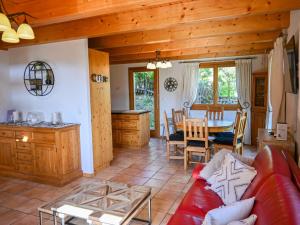 Una sala de estar con un sofá rojo y una mesa. en Chalet Ecureuil noir by Interhome, en Ovronnaz